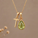 Gold Initial T Pendant and August birthstone Natural Peridot Necklace against a warm background