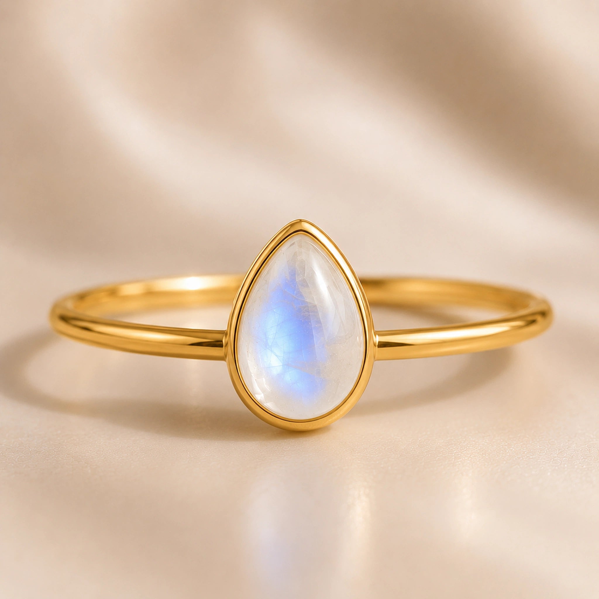 close up of gold vermeil teardrop natural moonstone ring on a light surface