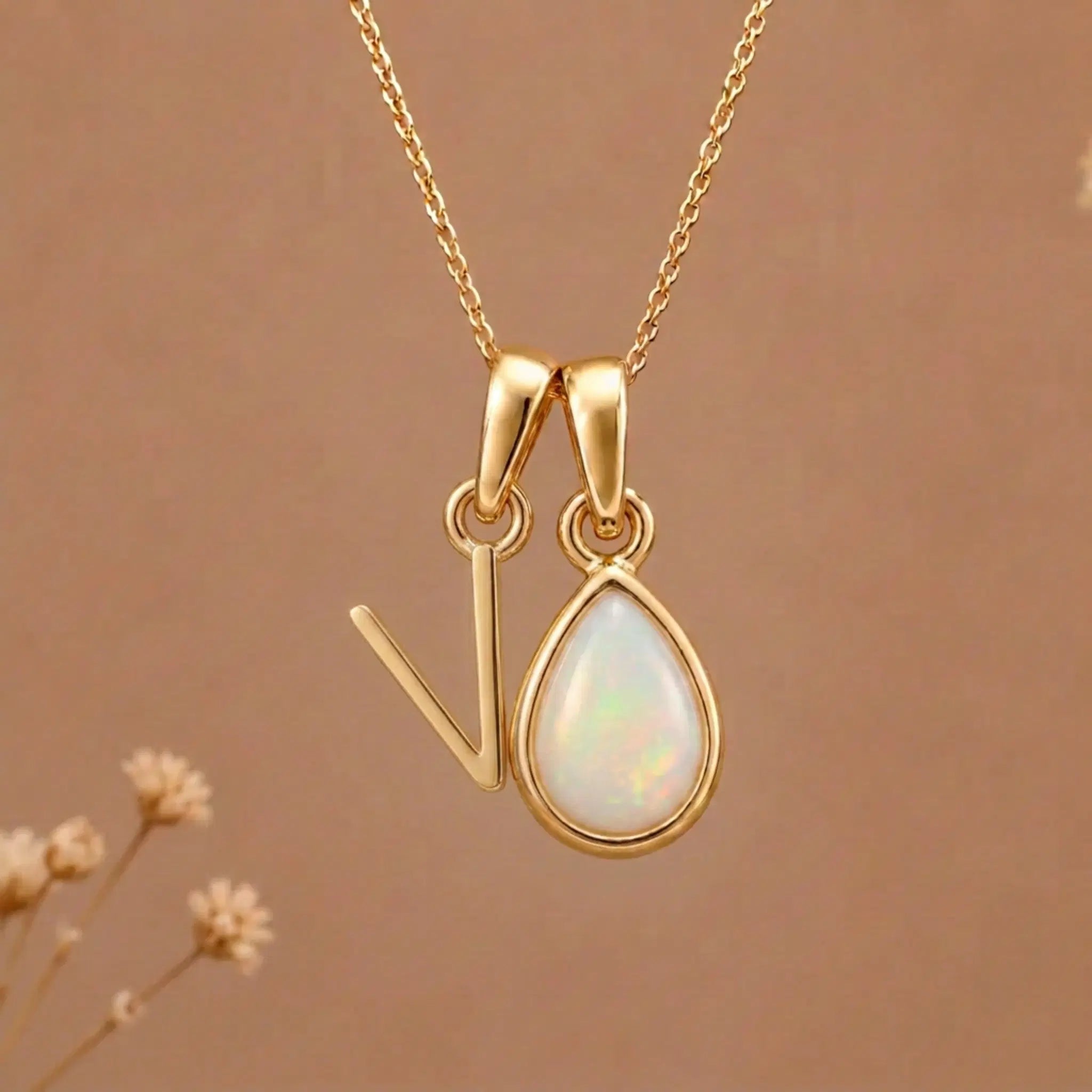 Gold Initial V Pendant and October birthstone Natural Opal Necklace against a warm background