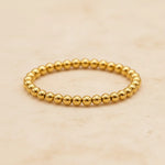 Gold vermeil beaded stacker ring on a beige background