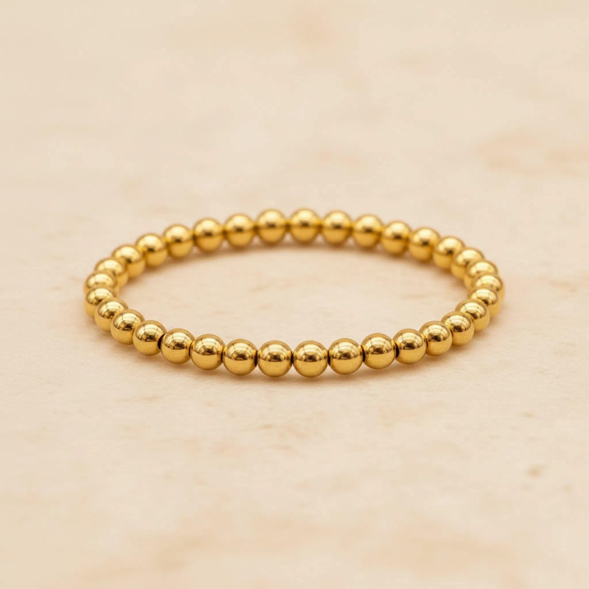 Gold vermeil beaded stacker ring on a beige background