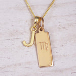 Gold Virgo initial necklace with a letter J pendant and zodiac bar on whitewashed wood
