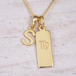 Gold Virgo initial necklace with a letter S pendant and zodiac bar on whitewashed wood