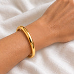 10 mm gold waterproof classic bangle bracelet worn on a wrist, 61 mm diameter, 18k gold plated stainless steel