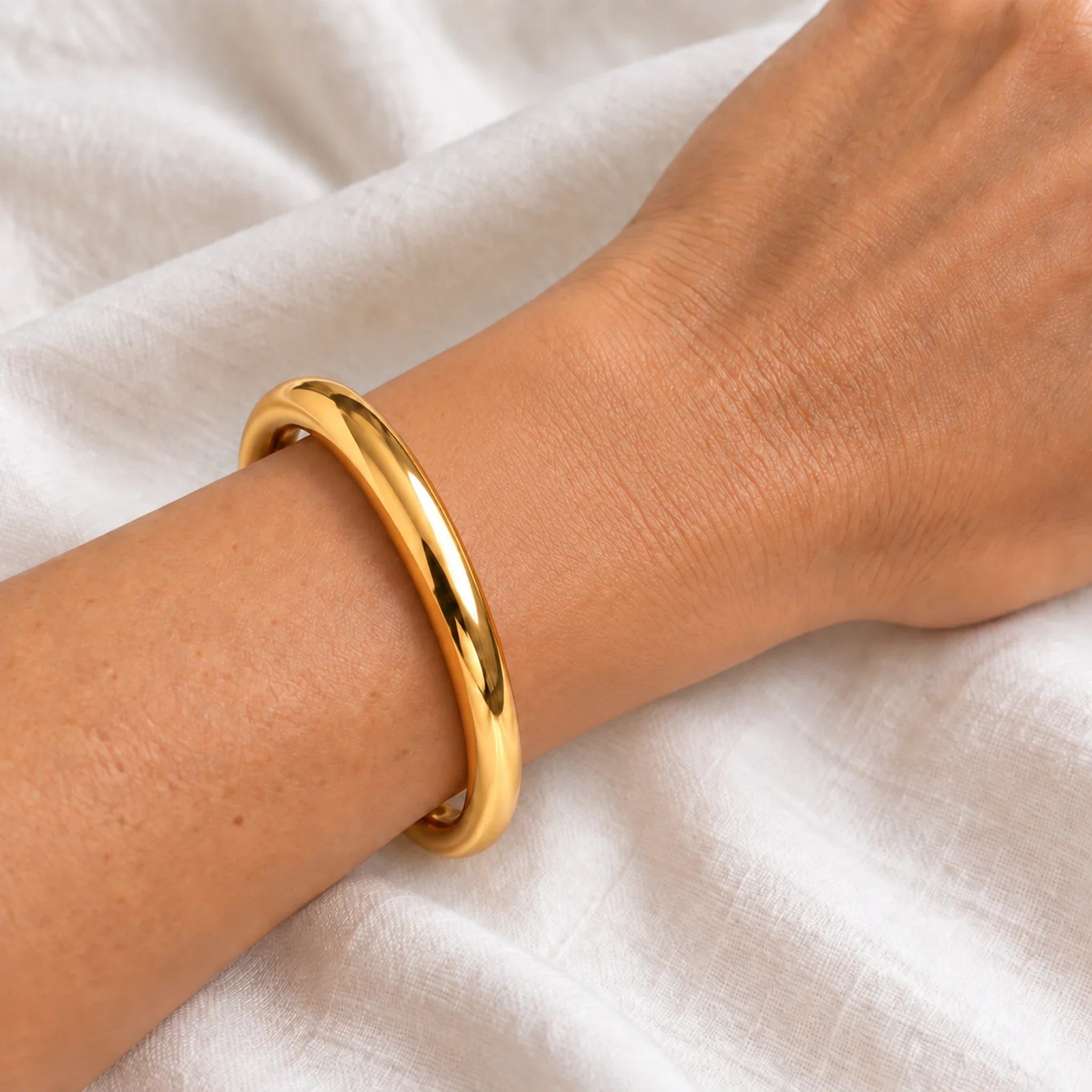 10 mm gold waterproof classic bangle bracelet worn on a wrist, 61 mm diameter, 18k gold plated stainless steel
