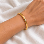 6 mm gold waterproof classic bangle bracelet worn on a wrist, 61 mm diameter, 18k gold plated stainless steel