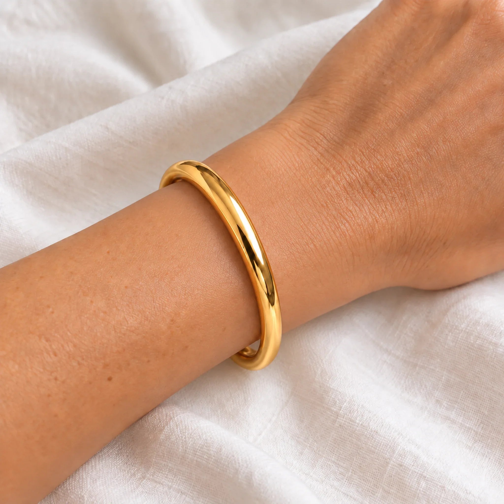 8 mm gold waterproof classic bangle bracelet worn on a wrist, 61 mm diameter, 18k gold plated stainless steel