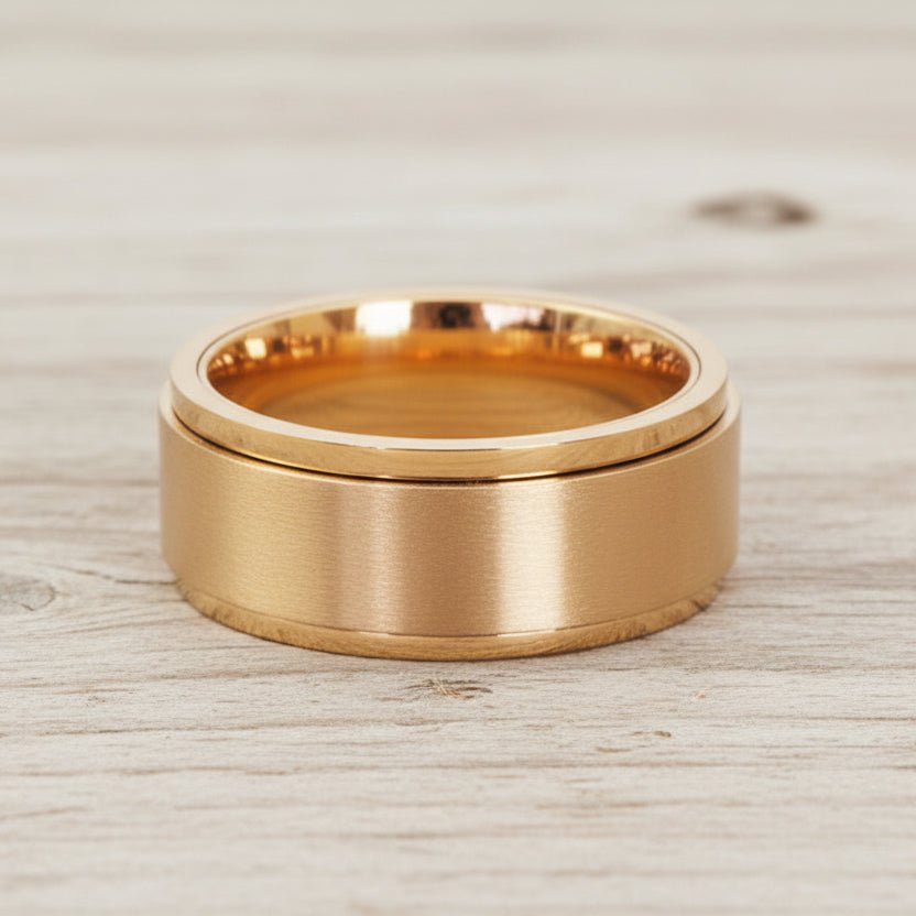 waterproof gold spinner Ring in minimalist stainless steel band design on a light wooden surface
