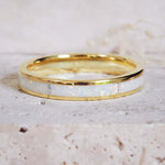 Gold ring with a white interior on a light beige background