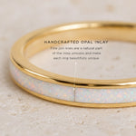 Gold ring with opal inlay on a beige background