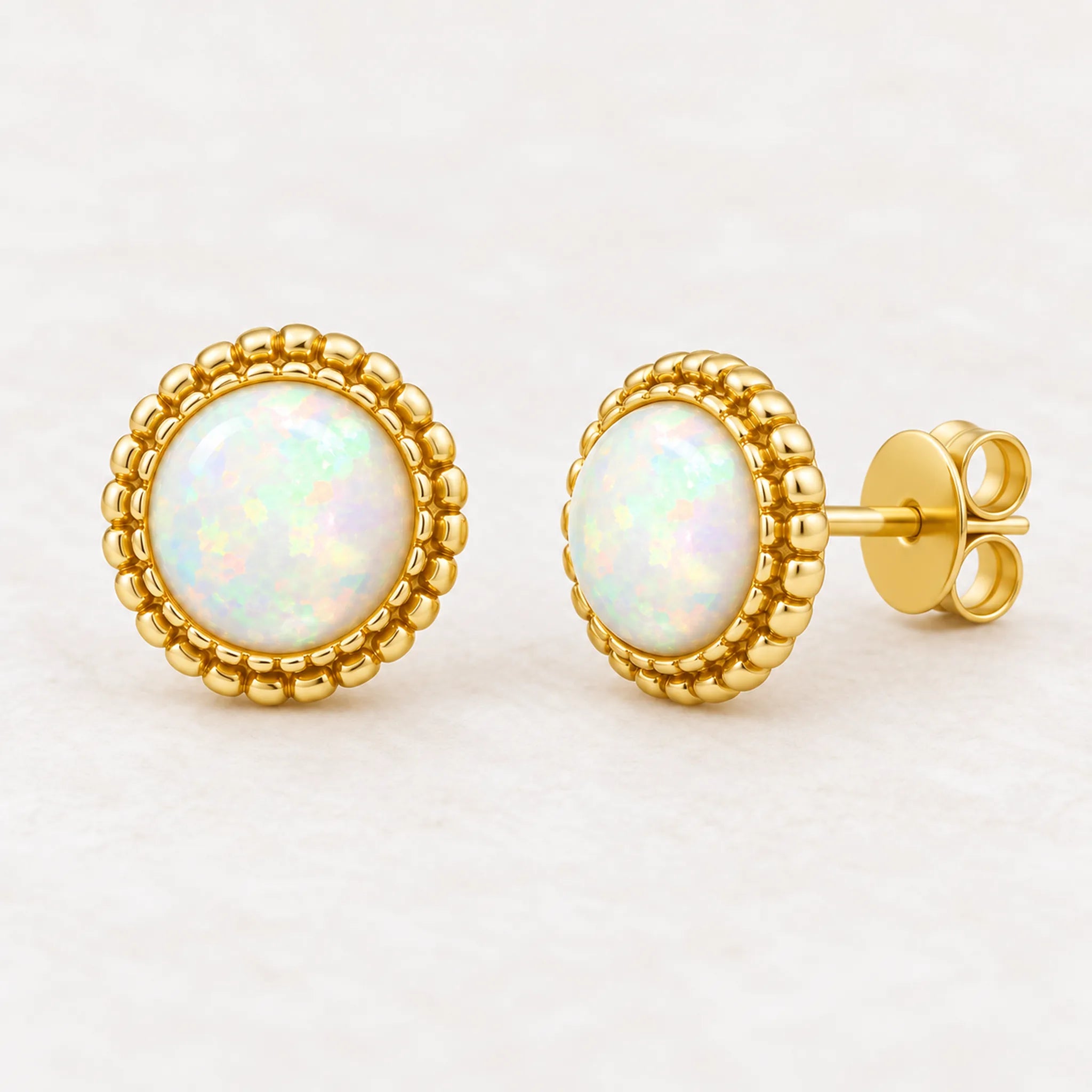 Gold white opal stud earrings, angled view