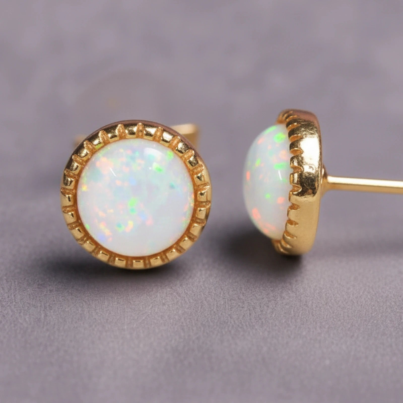 Gold White Opal stud earrings on a grey background