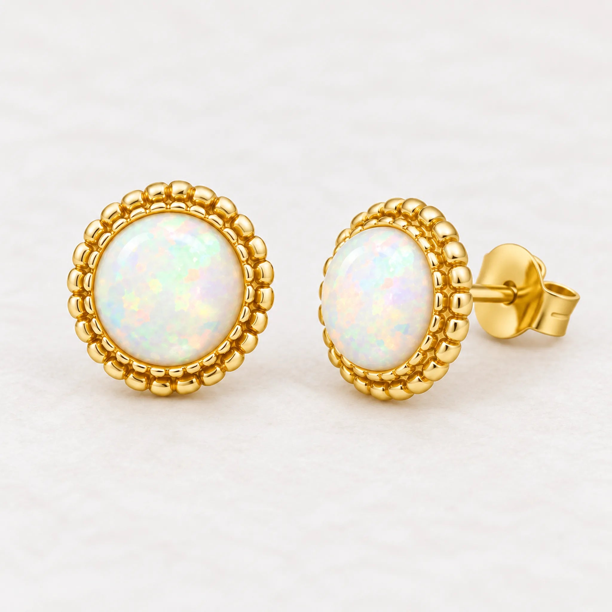 Gold white opal stud earrings, pair angled view
