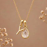 Gold initial Y necklace with an April clear quartz teardrop on brown with dried flowers