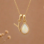 Gold Initial Y Pendant and October birthstone Natural Opal Necklace against a warm background