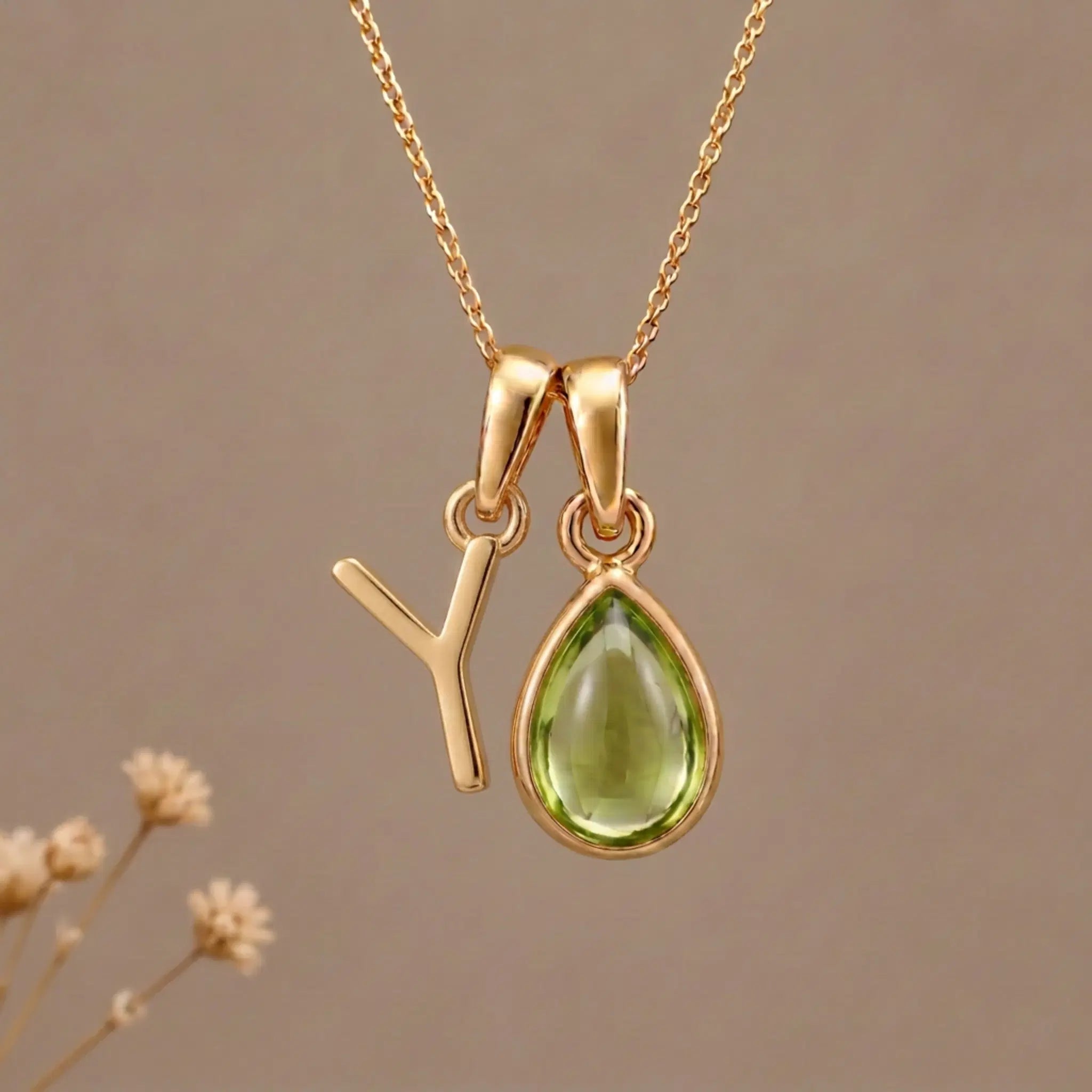 Gold Initial Y Pendant and August birthstone Natural Peridot Necklace against a warm background