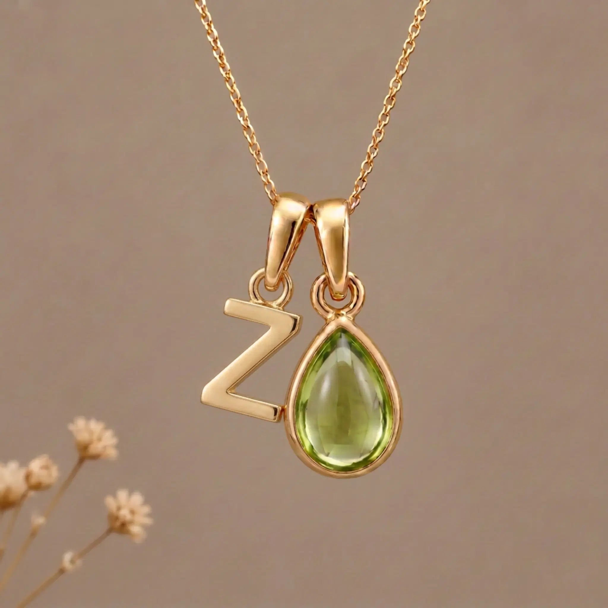 Gold Initial Z Pendant and August birthstone Natural Peridot Necklace against a warm background
