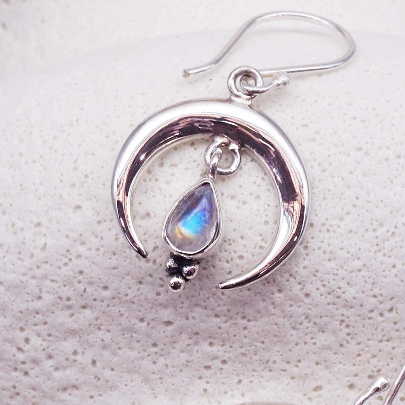 Sterling Silver earring with a teardrop-shaped Moonstone on a textured white background