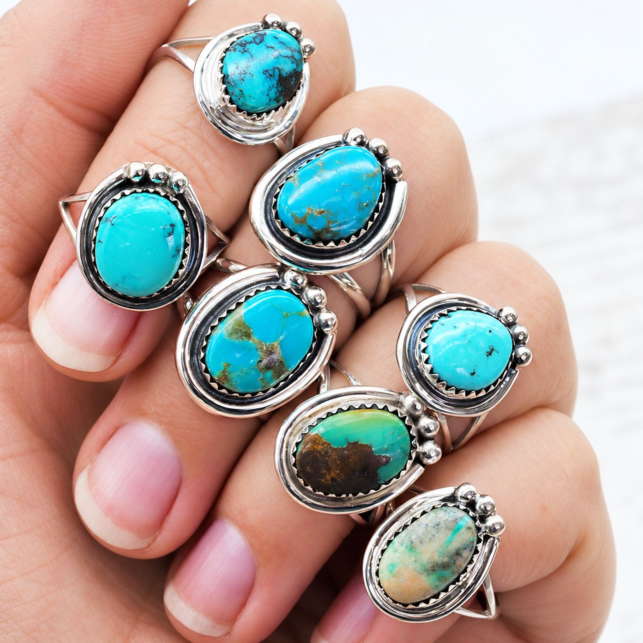 Hand wearing sterling silver Navajo turquoise rings