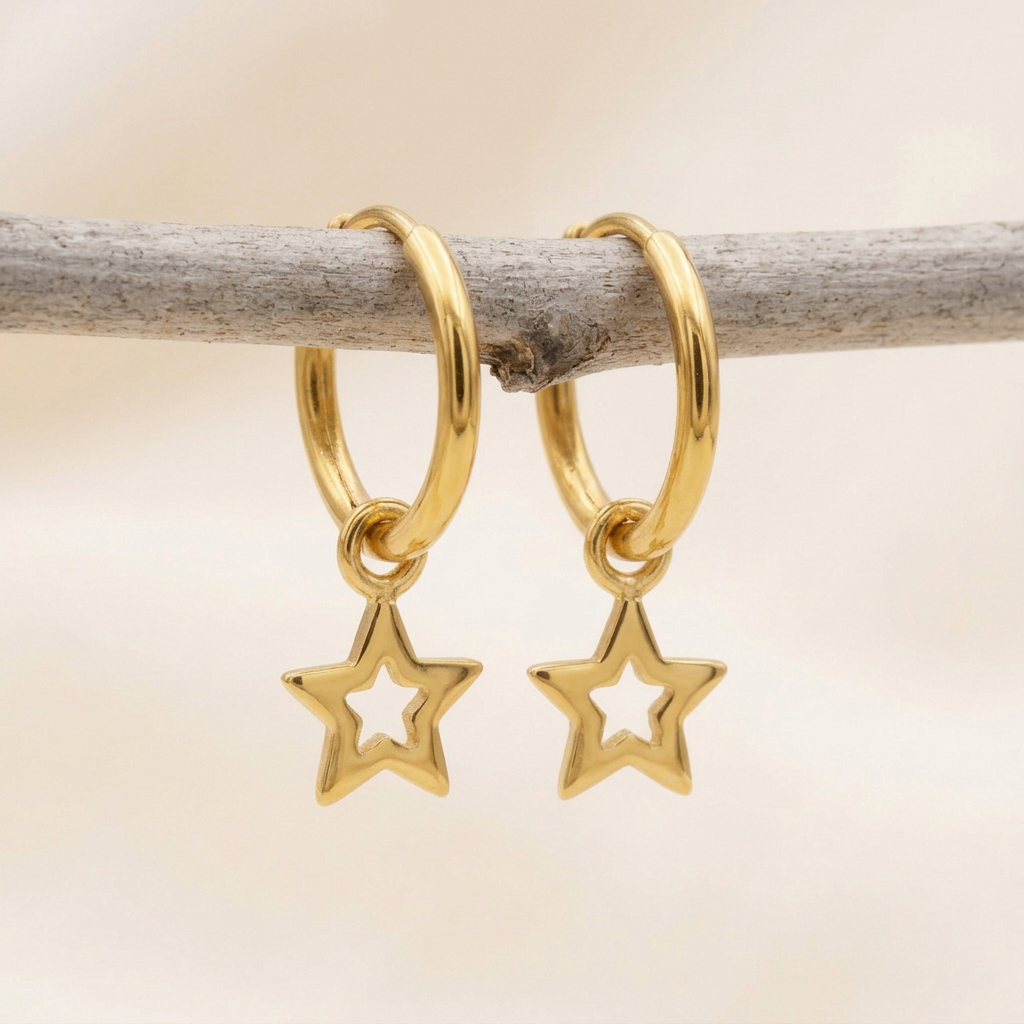 Highly polished reflective gold star earrings on a rustic branch