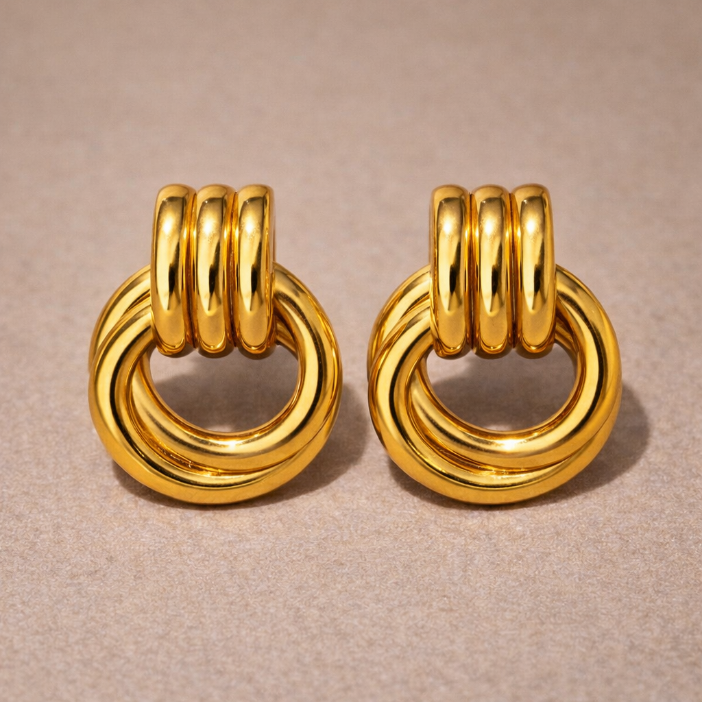 Pair of gold hoop earrings on a beige background