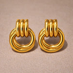 Pair of gold hoop earrings on a beige background