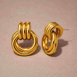 Pair of gold hoop earrings on a beige background