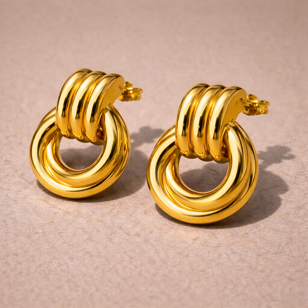 Pair of gold hoop earrings on a beige background