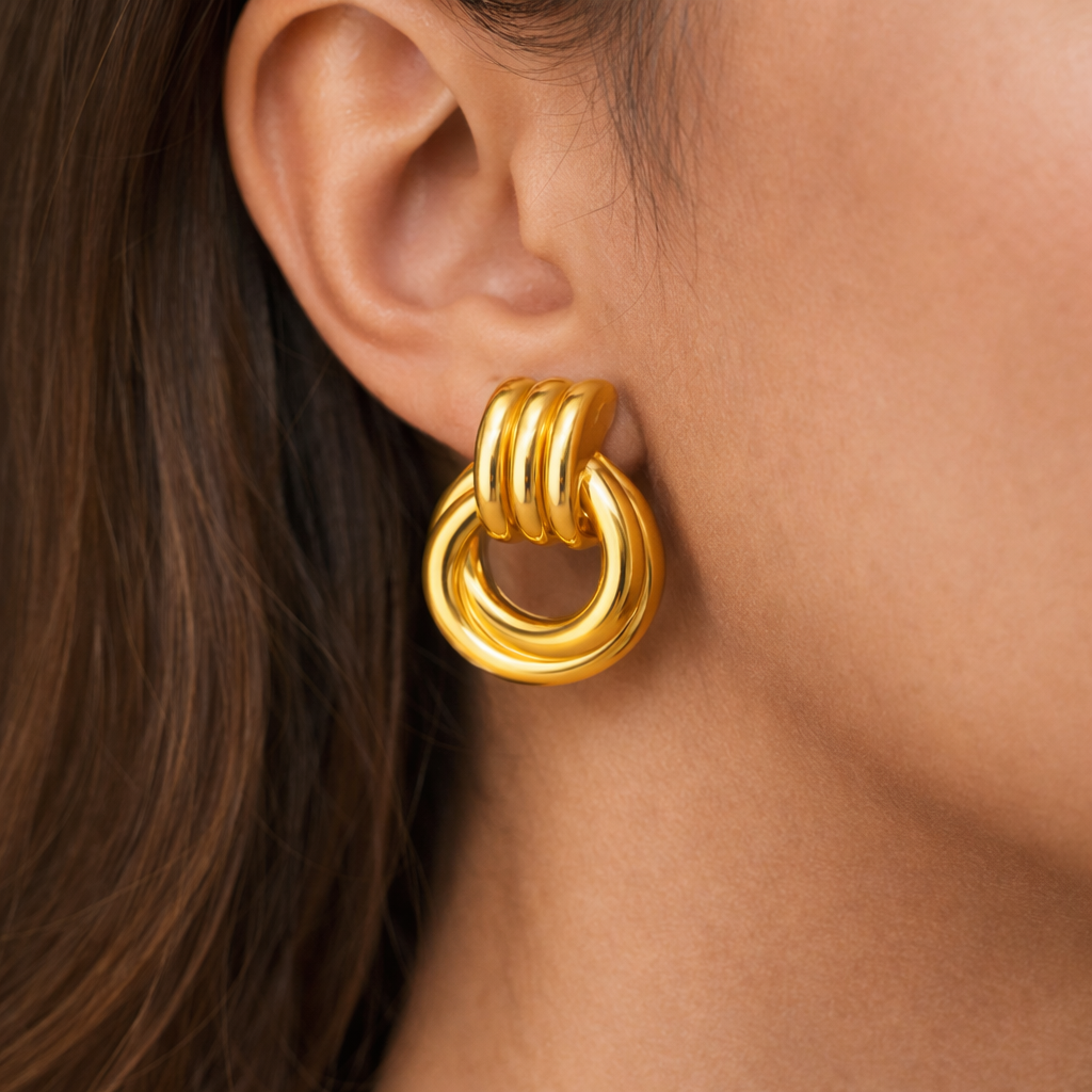 Gold hoop earring worn by a person with dark hair.