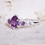 Silver ring with a purple gemstone on a light background