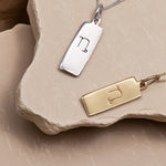 Gold and silver pendant necklaces with zodiac symbols on a stone surface