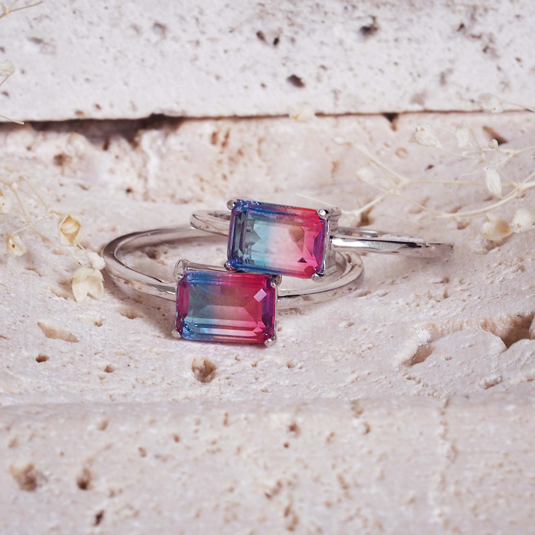 indie and harper - Silver ring with rectangular multicoloured gemstones on a textured beige surface