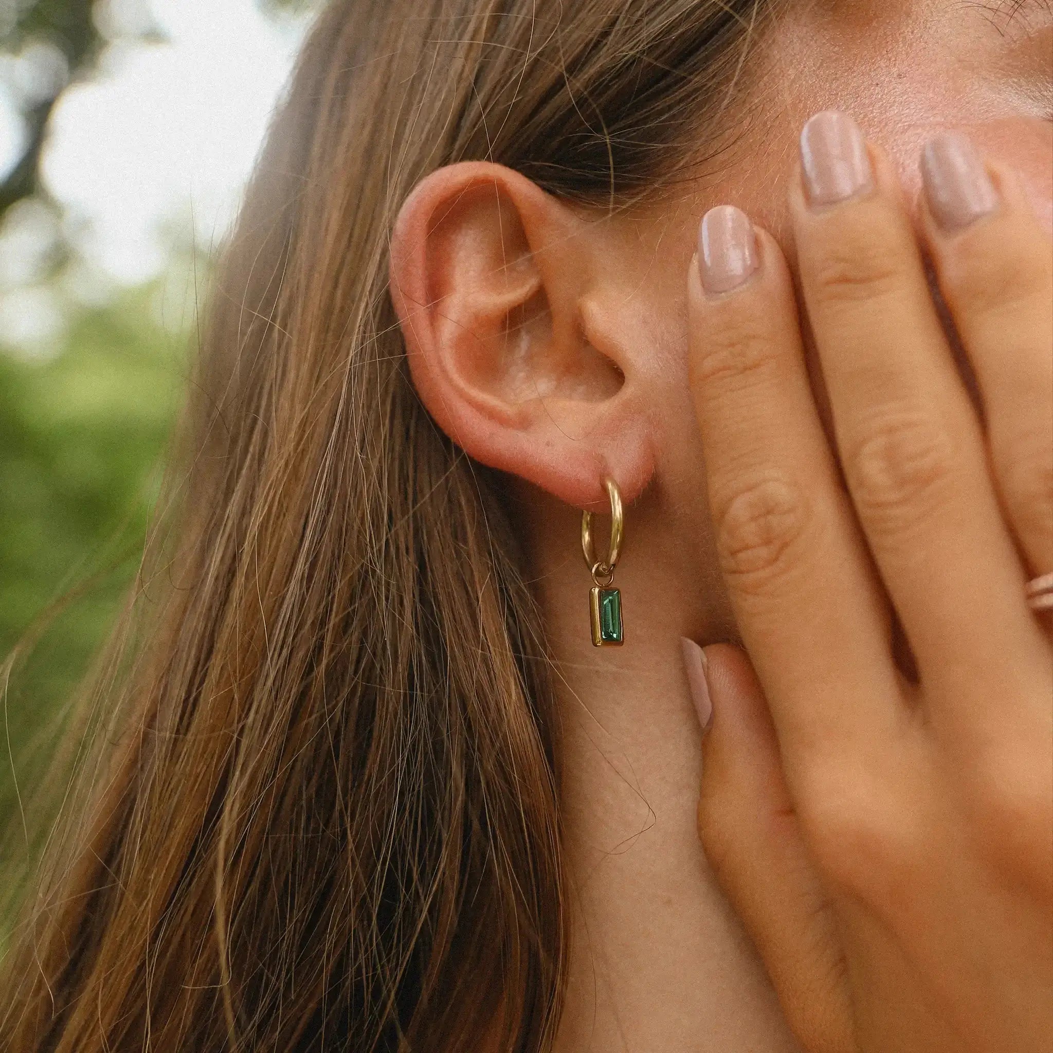 indie and harper dainty green and gold earrings being worn