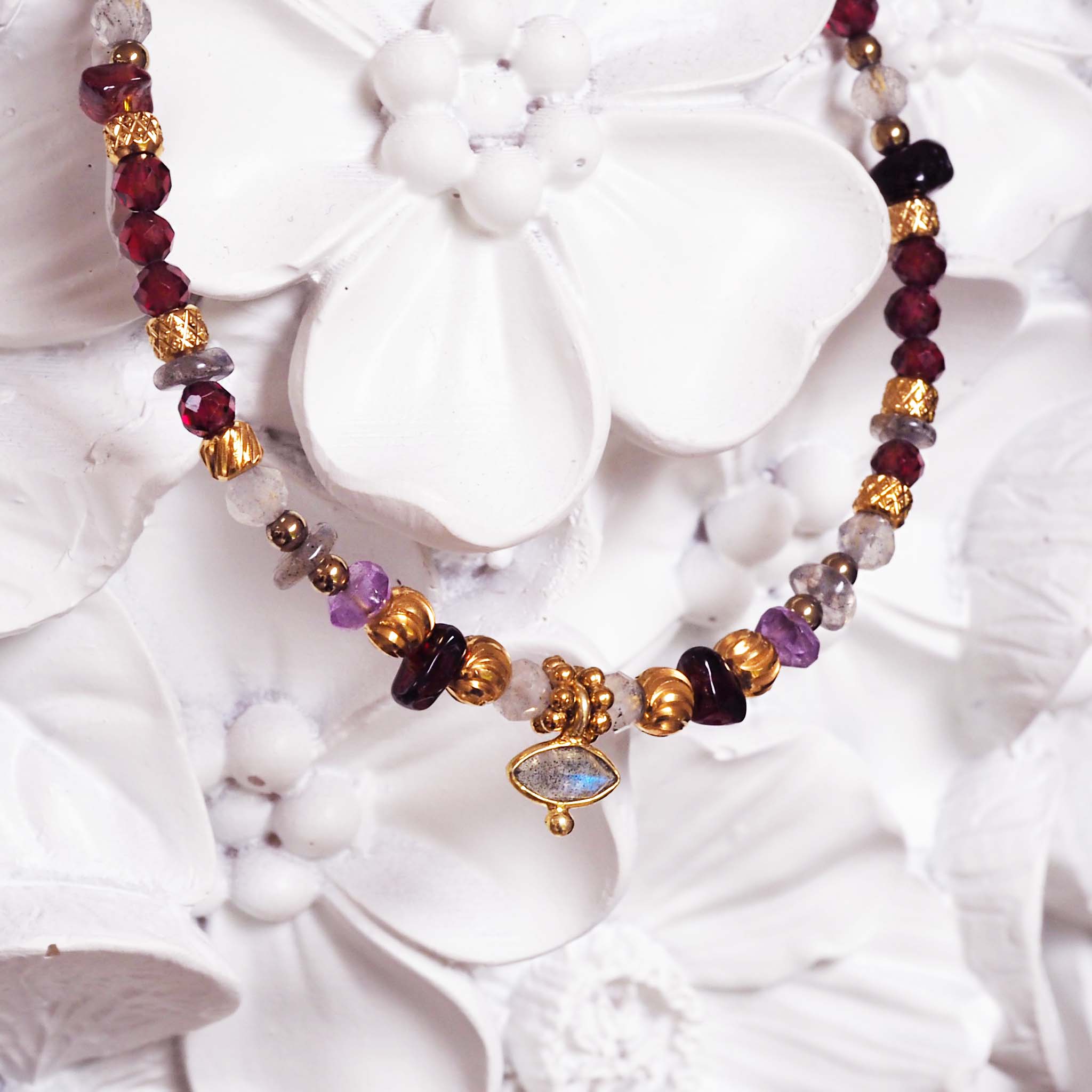 indie and harper bracelet with natural gemstones on a white floral background