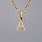 Gold necklace with a pendant shaped like the letter 'A' on a gray background