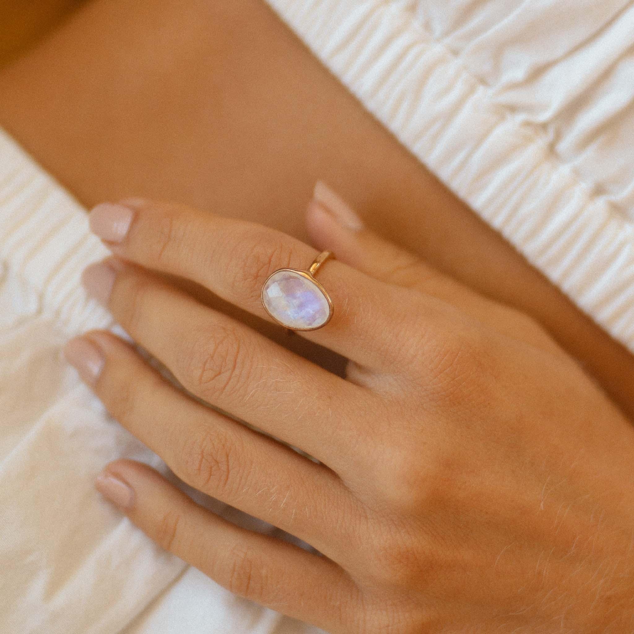 Statement Gold Rainbow Moonstone ring worn on hand, showing gold band and glowing stone