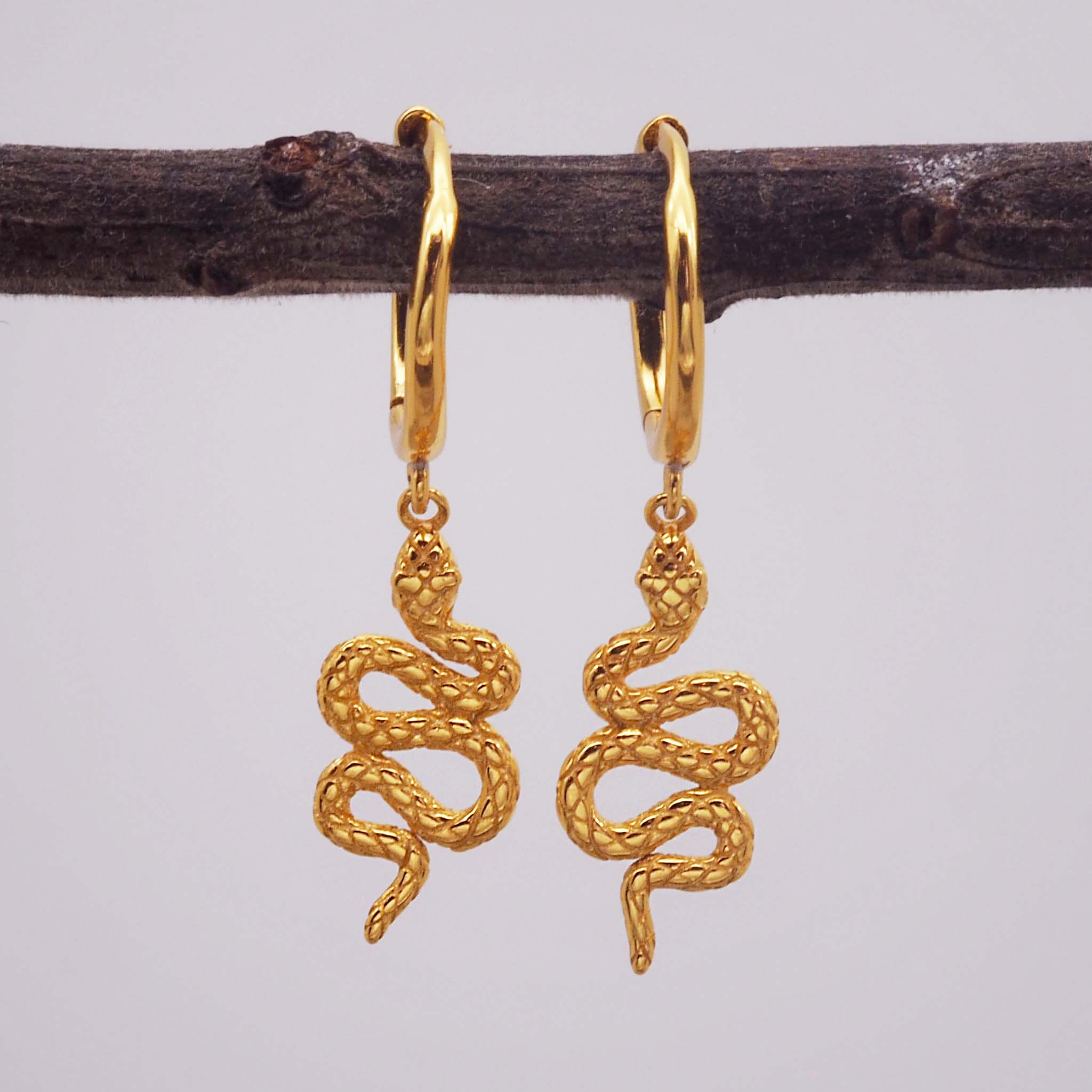 indie and harper gold huggie style earrings with serpent charm