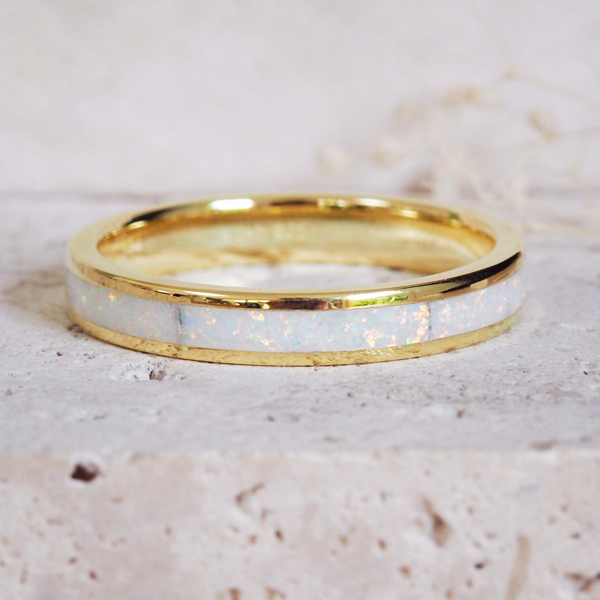 Gold ring with a white interior on a light beige background