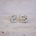 Pair of diamond stud earrings on a light background