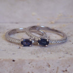 Two silver rings with blue gemstones on a textured surface
