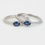 Two silver rings with blue gemstones on a white background