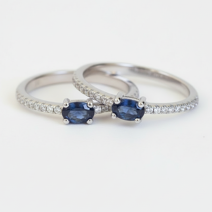 Two silver rings with blue gemstones on a white background