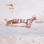 Rose gold ring with diamonds on a light background
