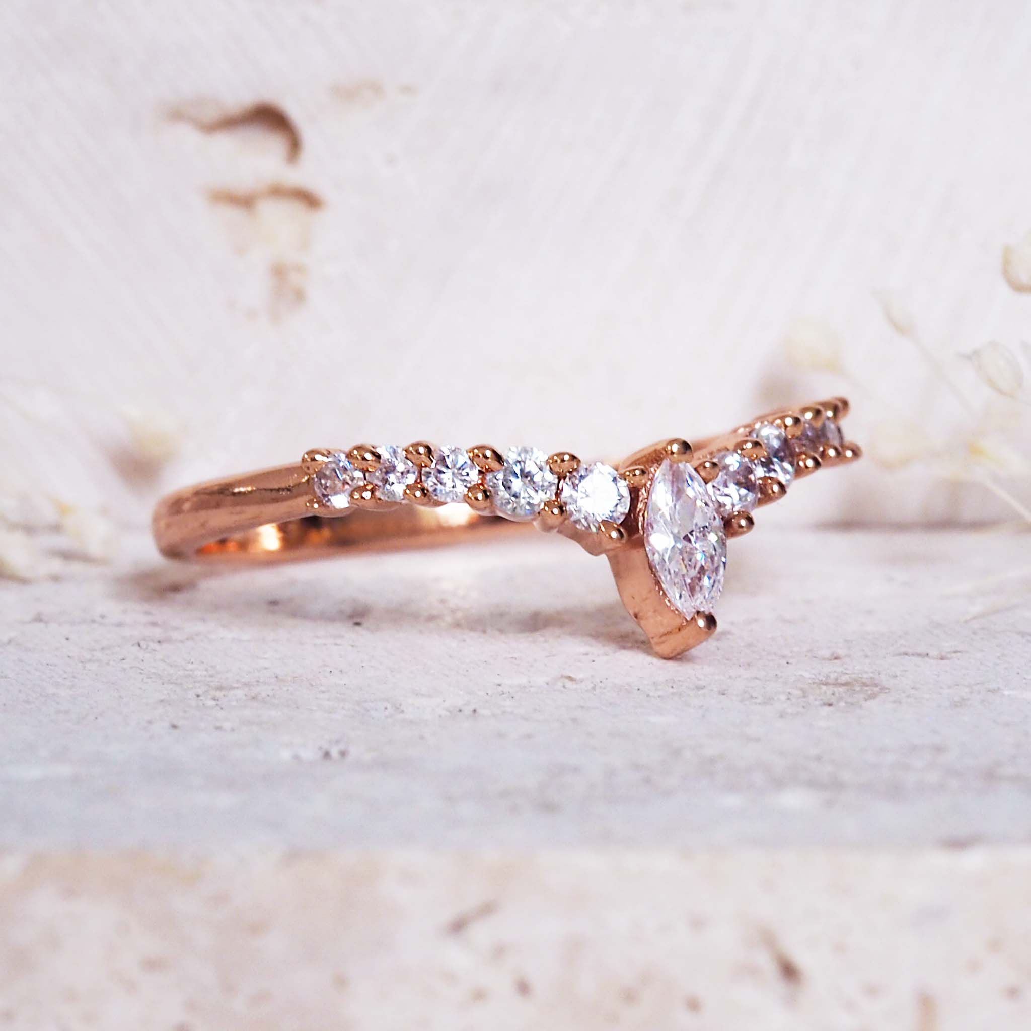 Rose gold ring with diamonds on a light background