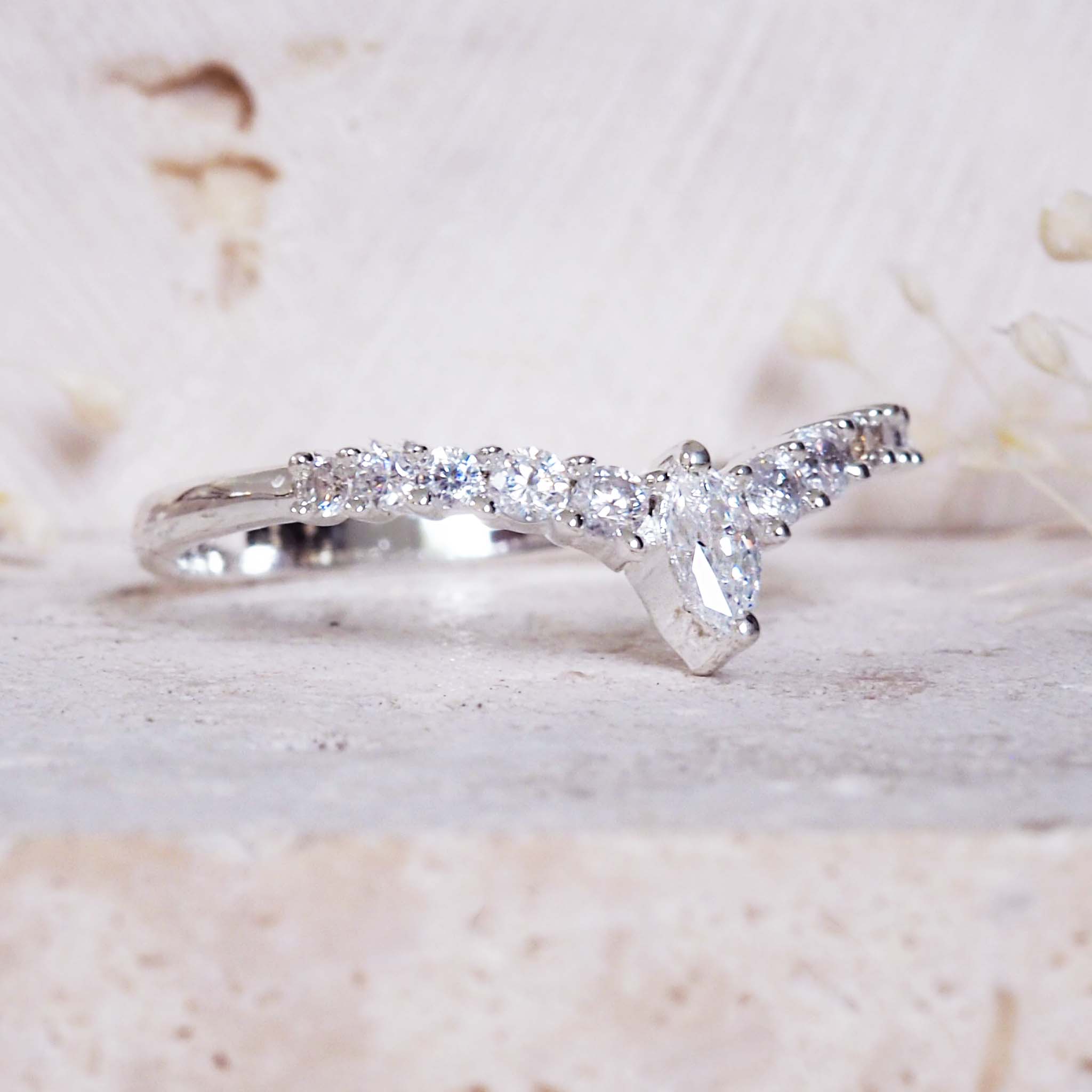 Silver ring with diamond-like stones on a light background