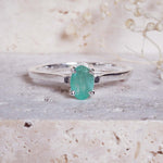 indie and harper sterling silver ring with a green emerald gemstone on a textured surface