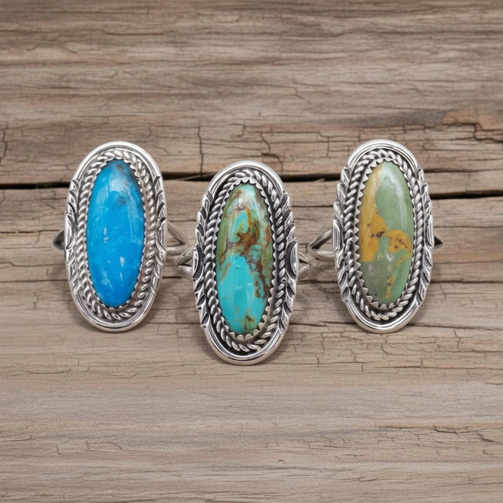 Three silver Navajo turquoise rings on a white stone surface