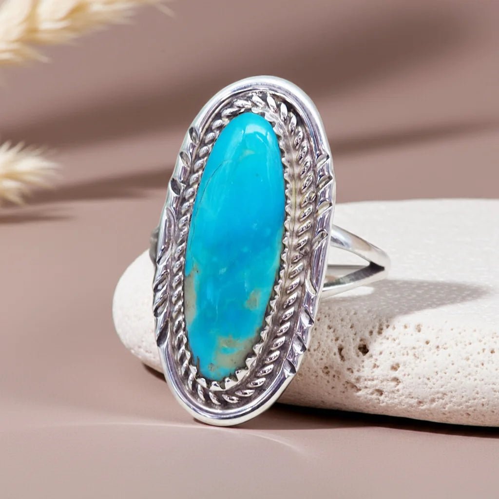 Silver ring with a turquoise stone on a beige background