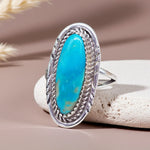 Silver ring with a turquoise stone on a beige background
