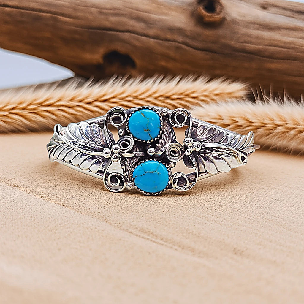 Silver bracelet with turquoise stones on a wooden surface